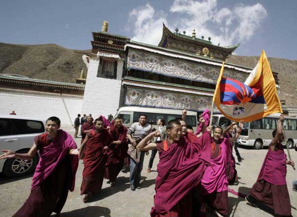 Tibetan Monks carry their national flag and shout slogans as a group of journalists, invited to an official visit by the local government, arrived at the Labrang Monestry, eastern Tibet, April 9, 2008. Photo: TPI