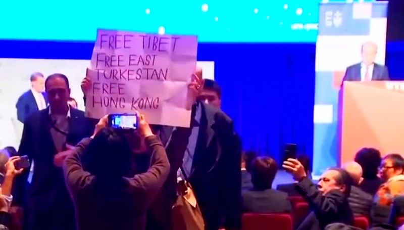 A protester holding a banner reading "Free Tibet" raised in front of a Chinese diplomat during his speech at the UTS, 24 June 2022. Photo: File