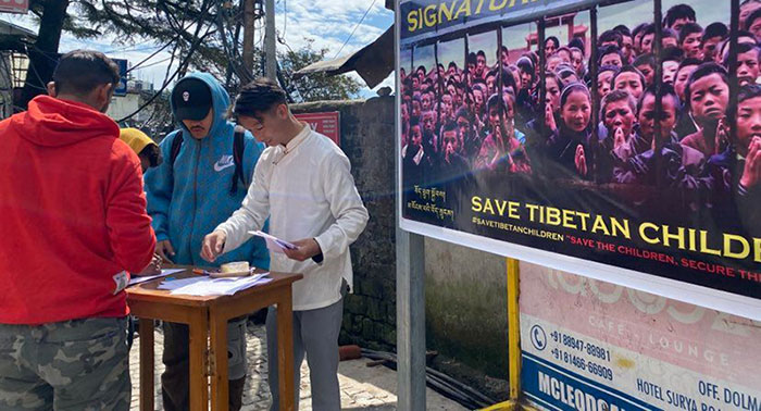 People signing the petition at the main square of Mcleod Ganj, Dharamshala, on October 12, 2022. Photo: TPI